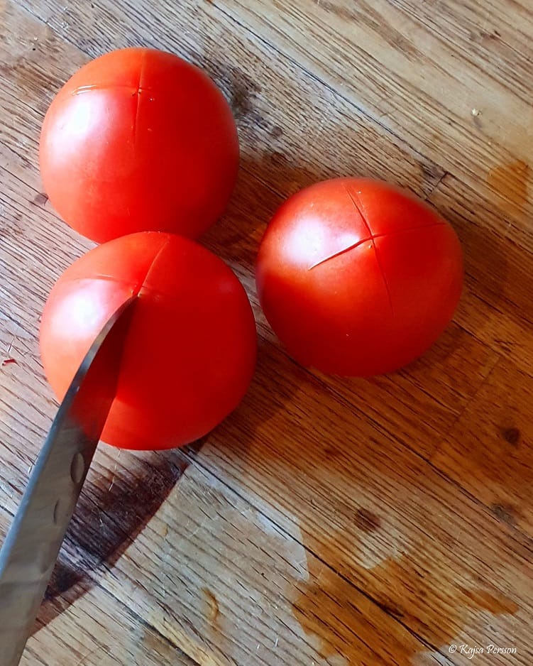 Tomater med kniv som skär en skåra