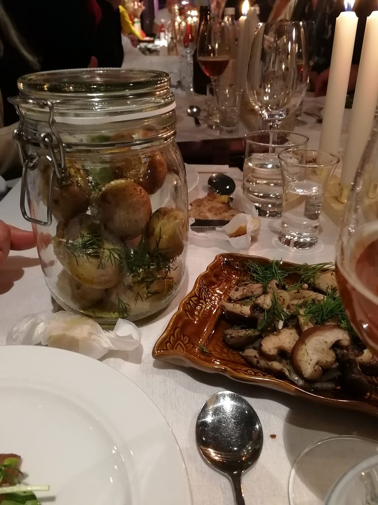Potatis i glasburk och svamp på brun tallrik i en vacker dukning på Glocal dinner