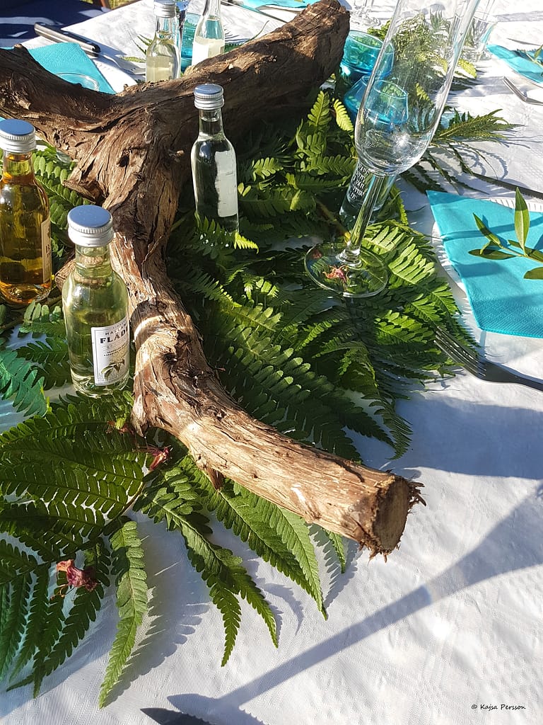 Ormbunke, trästock passar fint med snapsflaskor och vinglas på bordet